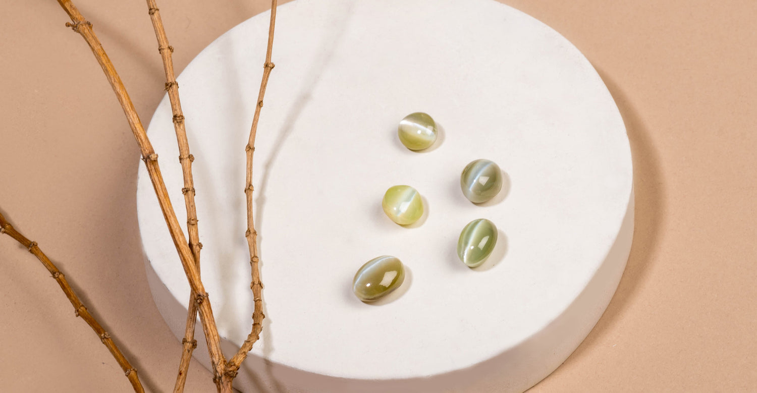 Creative banner image of chrysoberyl cat's eye gems on a white circular plate