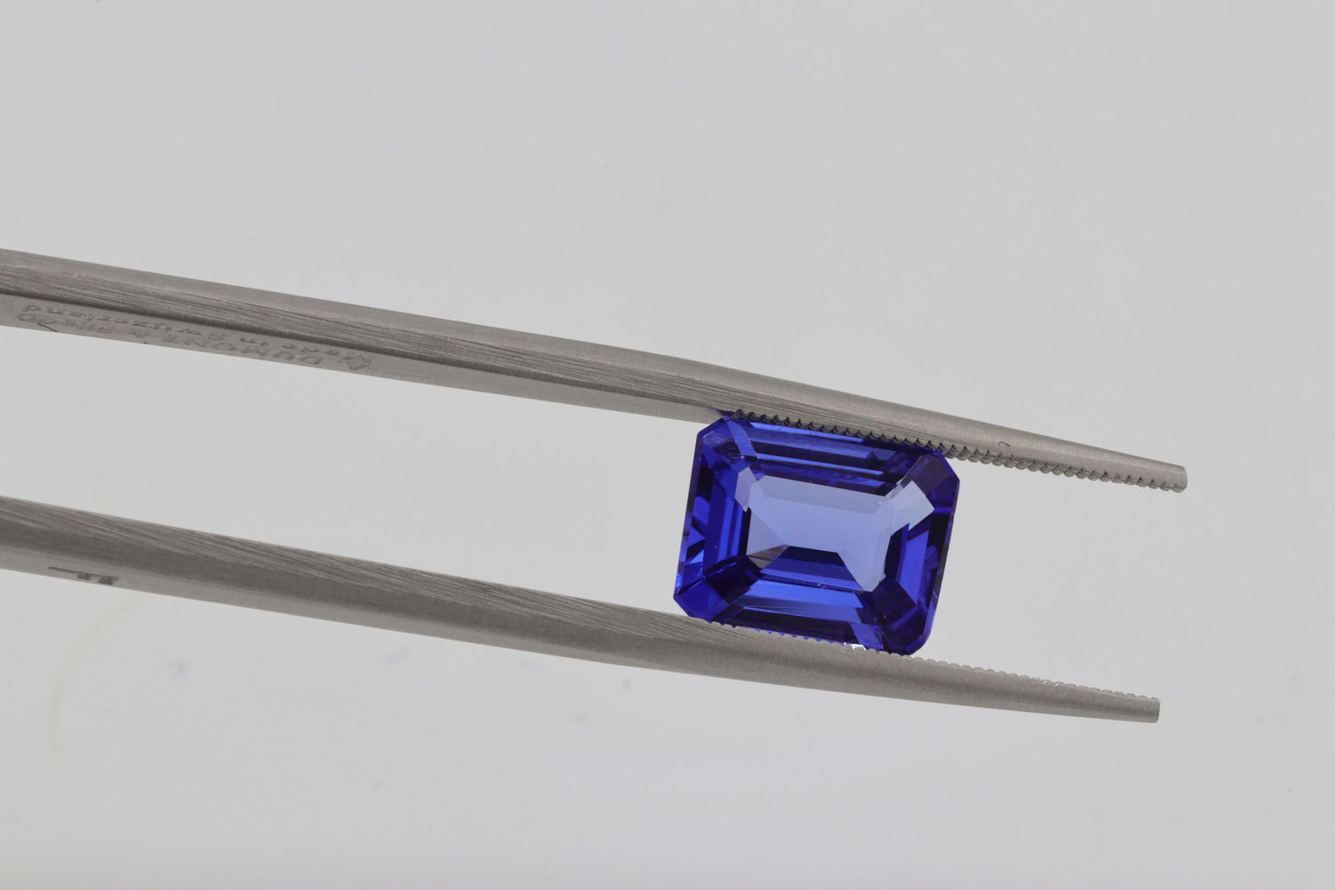 Blue sapphire gem on a tweezer