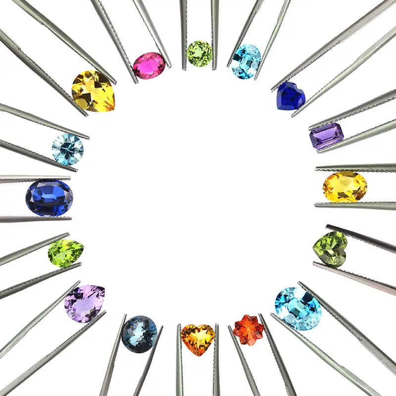 Circle of coloured gemstones held with tweezers