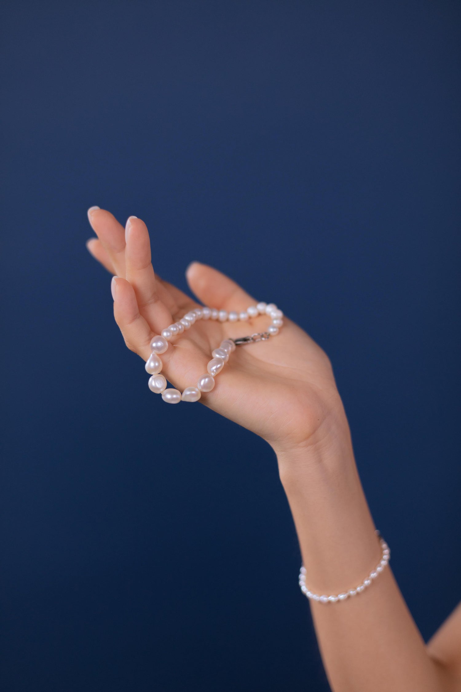 Hand holding a pearl bracelet