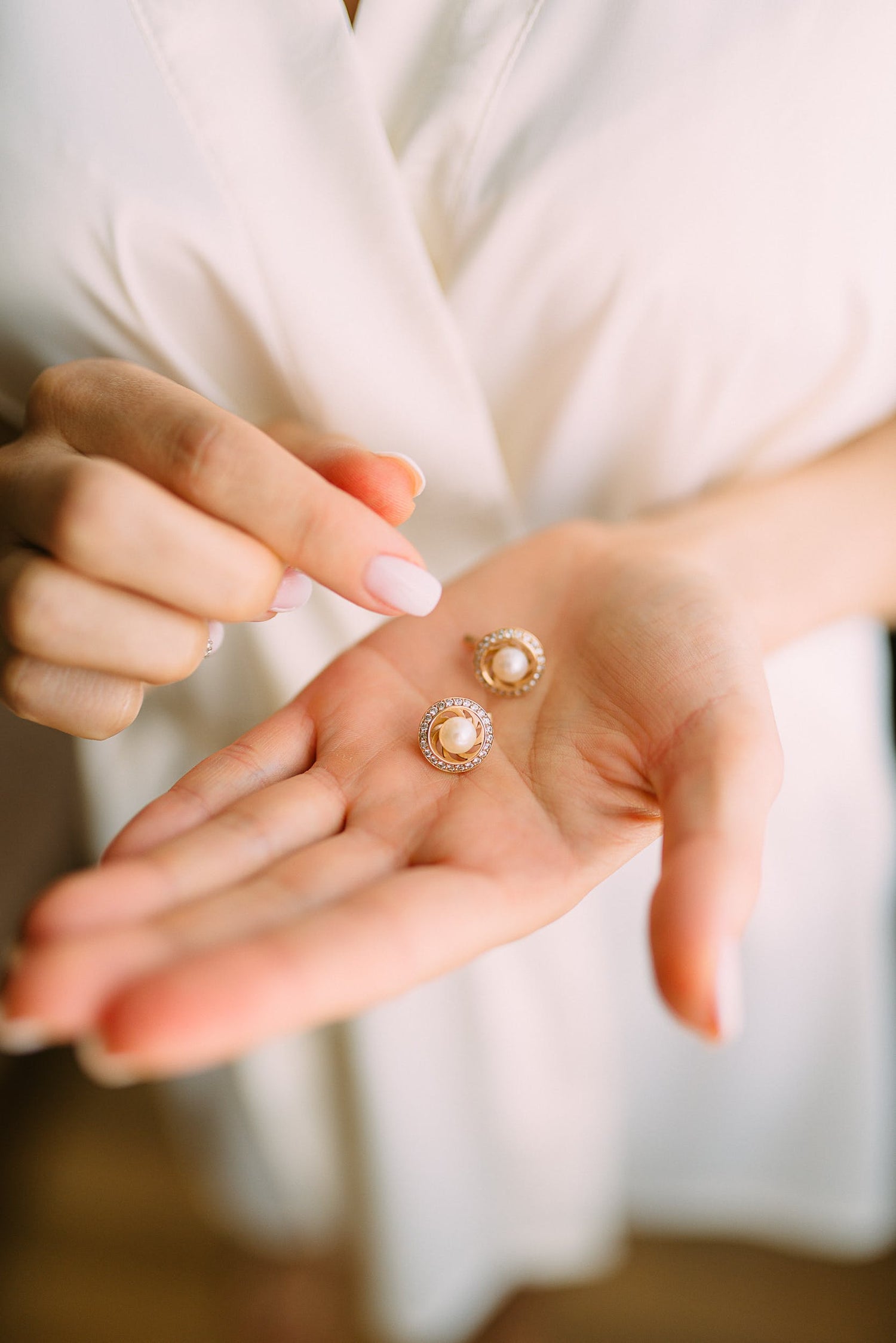 Pearl earrings held on a palm