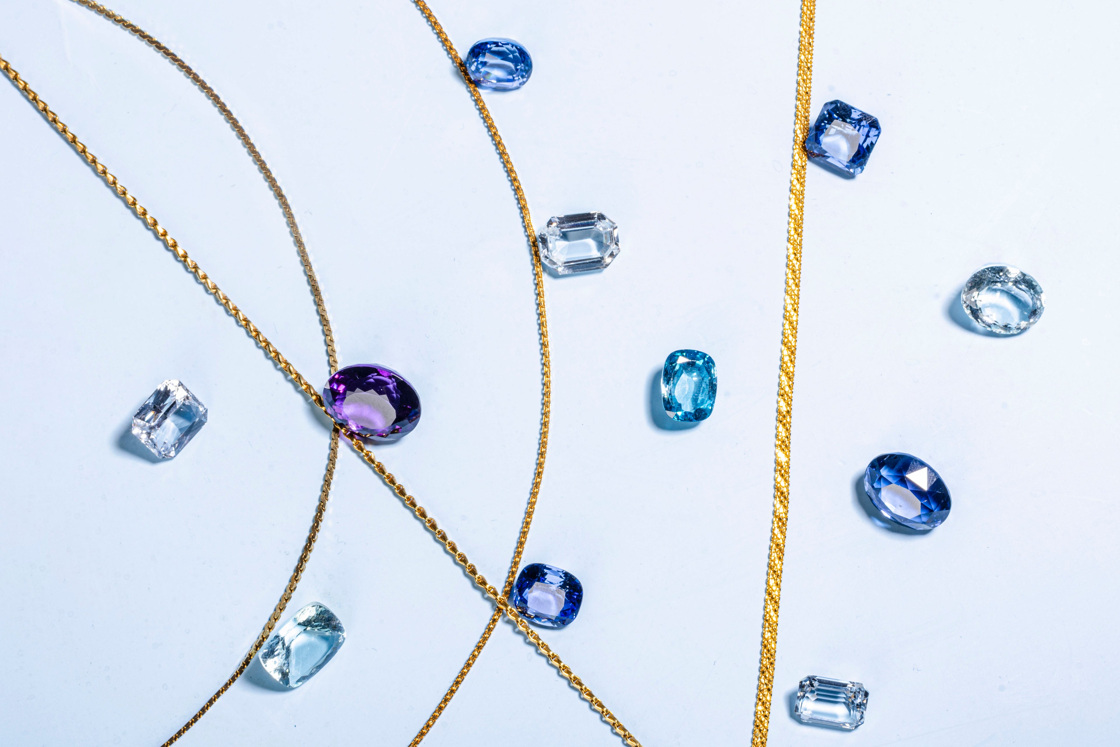 cut and polished coloured gems along a gold chain